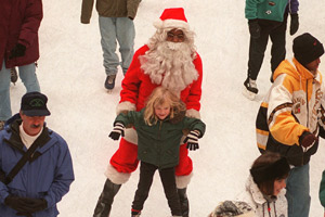 Akin Dawopu, dressed as an ice-skating Santa Claus, helps an unidentified young girl skate at the rink at Rockefeller Center in New York City, Sunday, Dec. 24, 1995. (AP Photo/Adam Nadel)